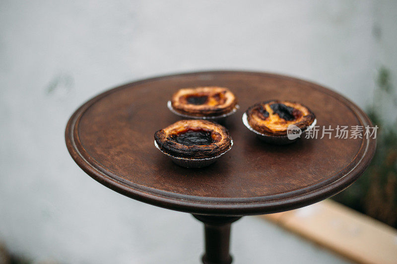 柔和的de nata。传统的葡萄牙蛋糕放在古老的木桌上